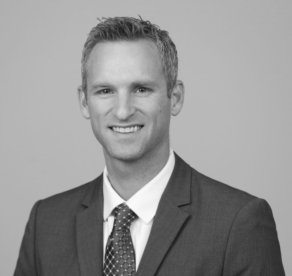 Headshot of Nick Farris, smiling in a collared shirt and tie with an orange microphone to the left of the image